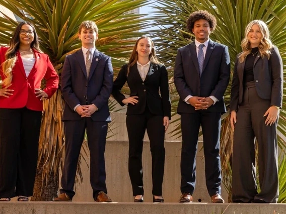 students in suits pose for a photo