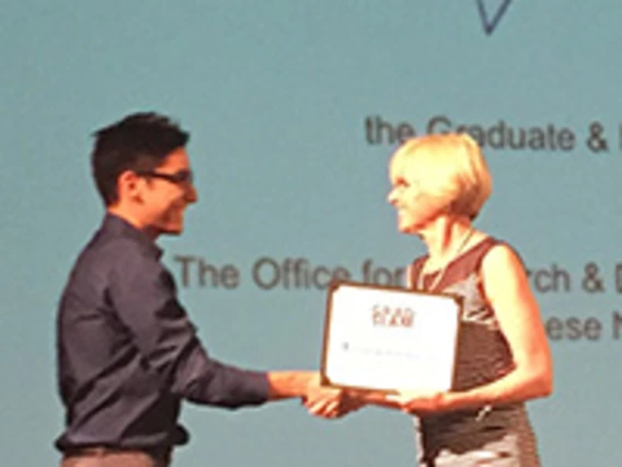 man and woman shaking hands, woman holding an award