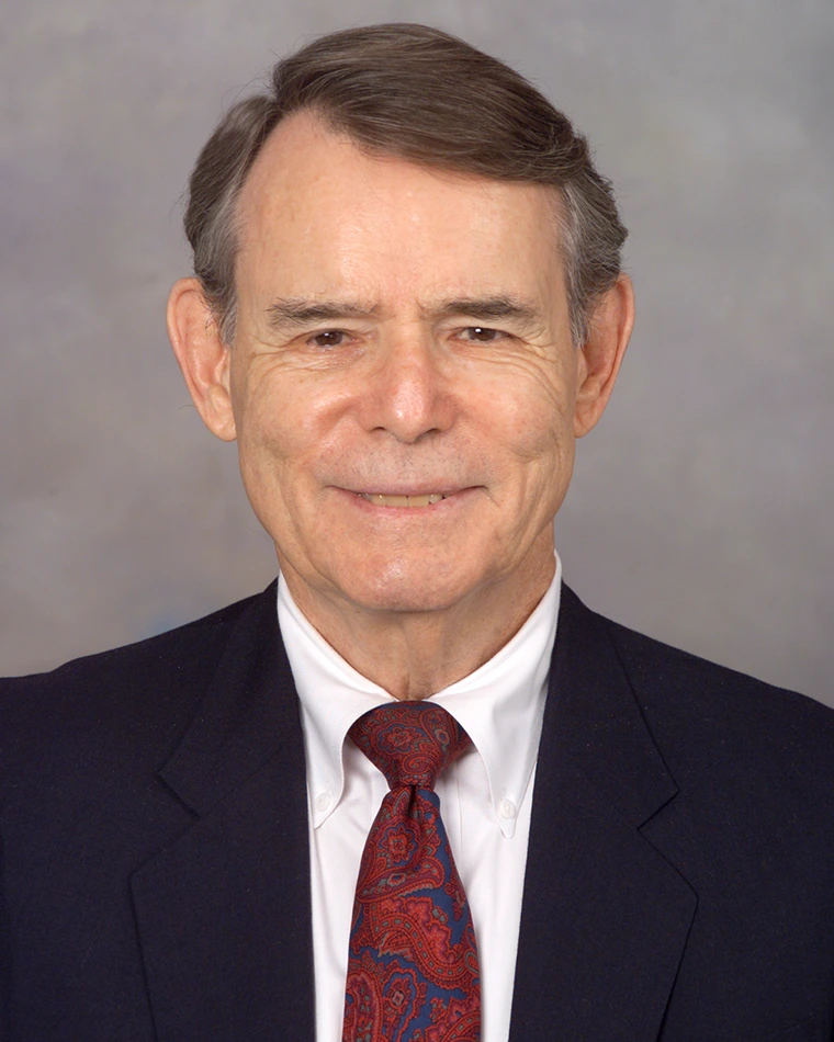 portrait of person in dark blue suit and red tie